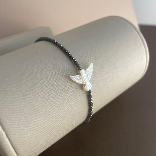 Pulseira de Hematita com Divino Espírito Santo em Madrepérola e Liga de Silicone – Proteção e Estilo em Harmonia