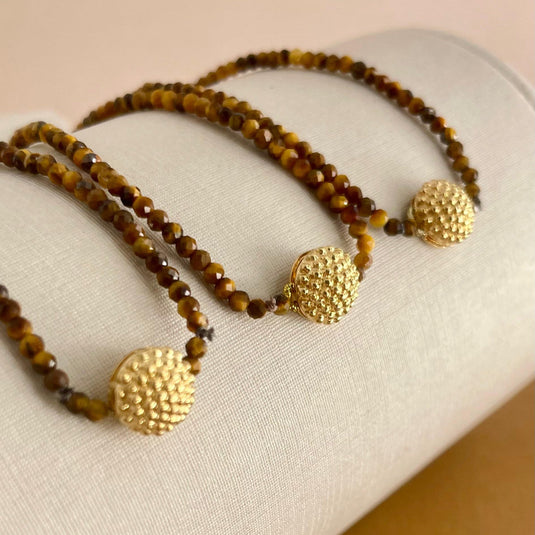 Pulseira de Olho de Tigre com Pingente de Bola em Ouro 18k – Elegância e Poder Natural